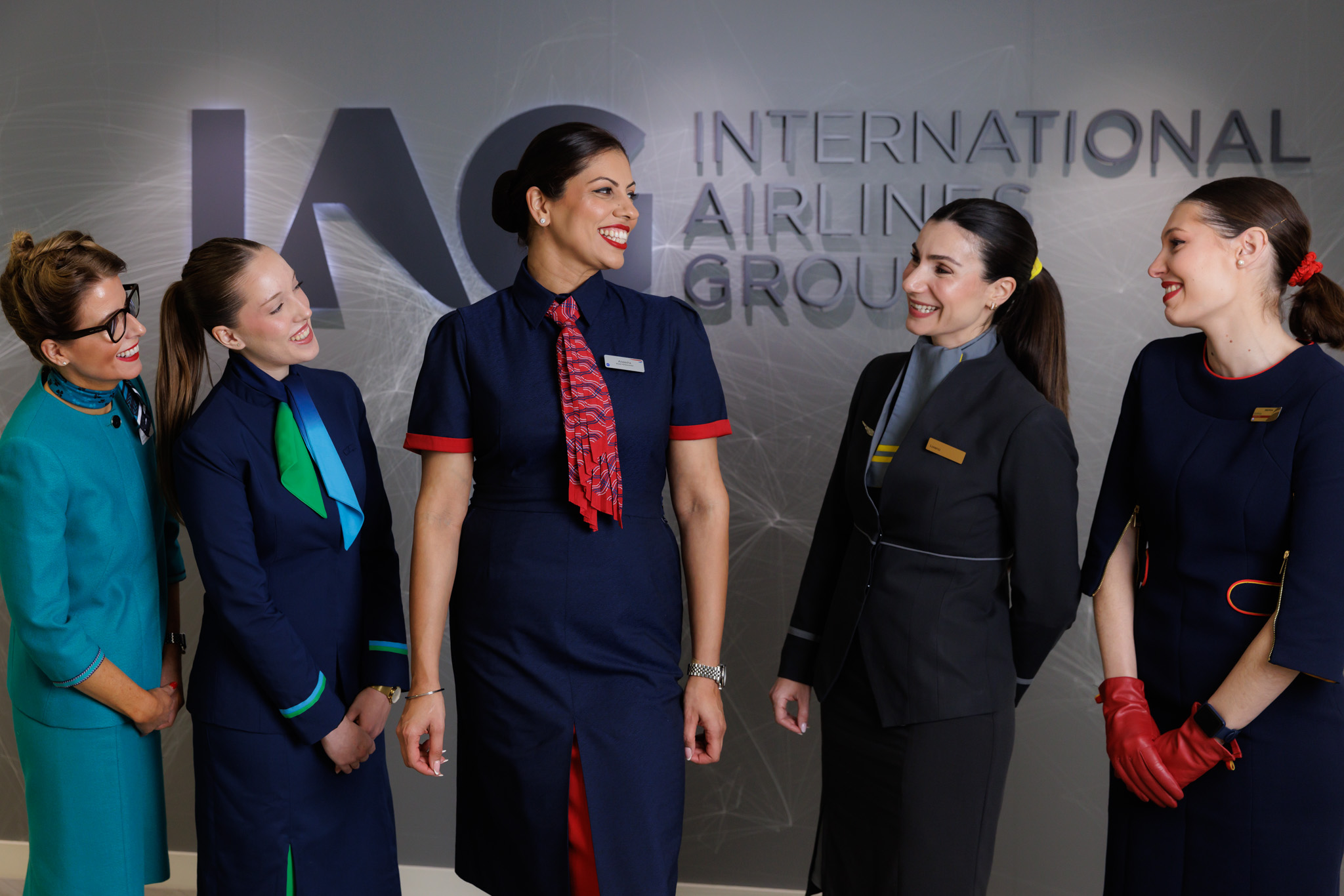 Cabin crew from IAG airlines posing in front of IAG logo