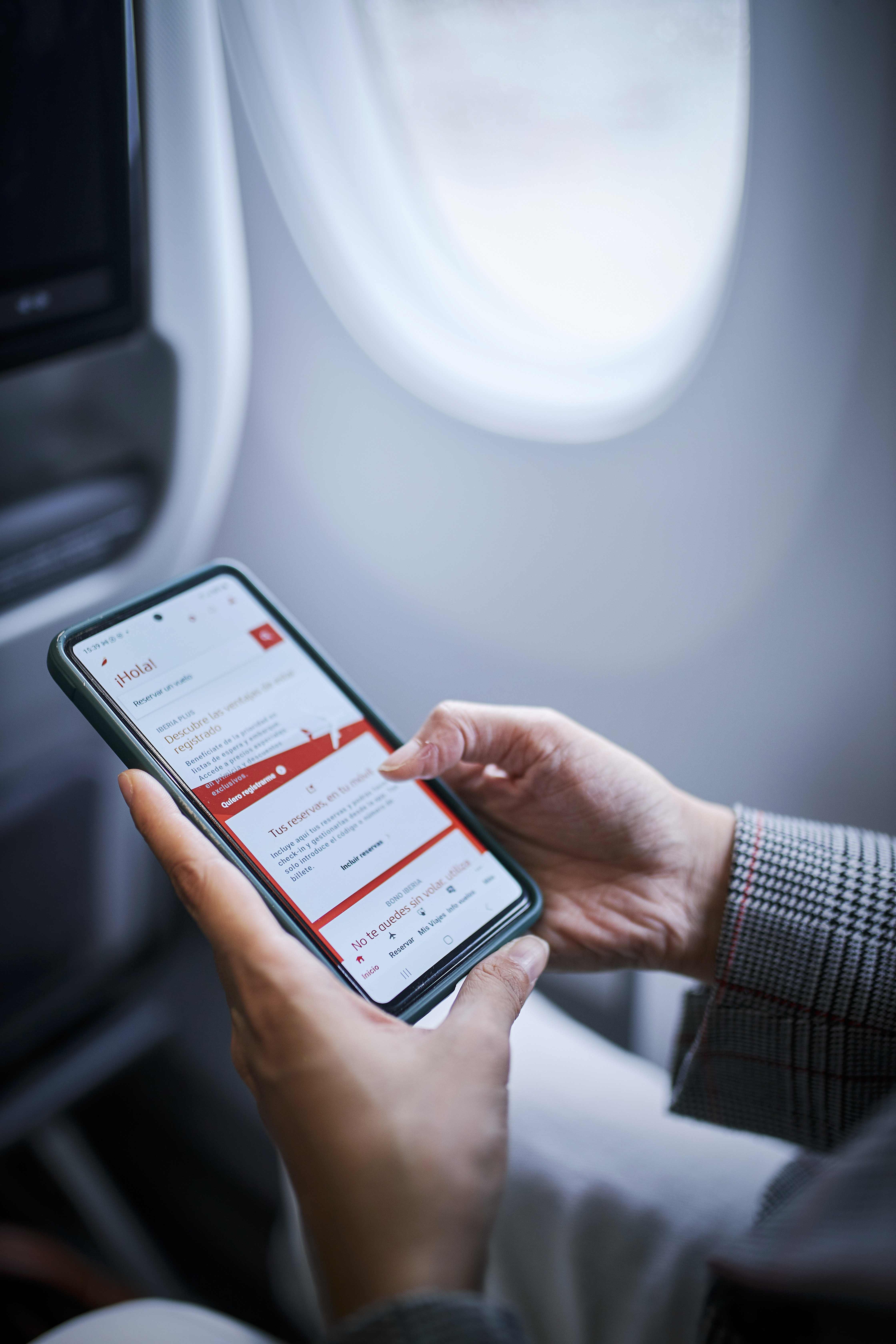 Customer using Iberia app on board plane